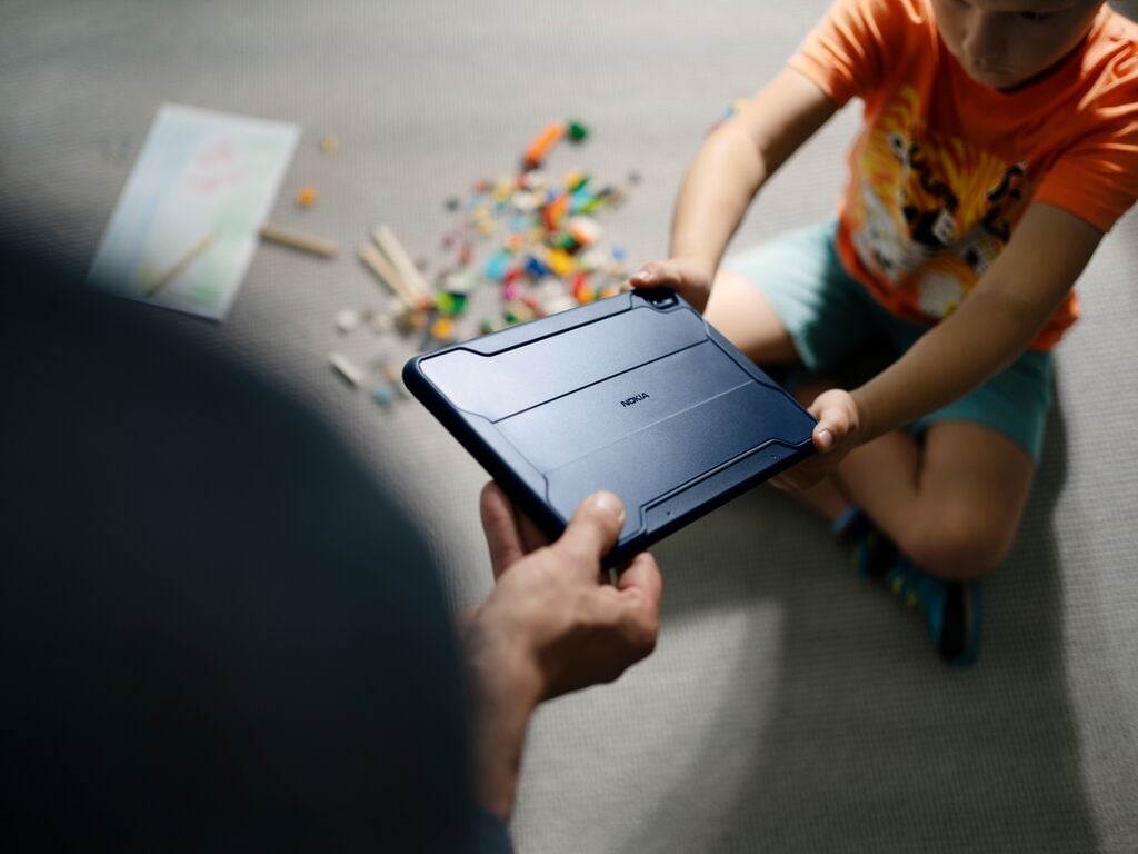 child handing a tablet to an adult