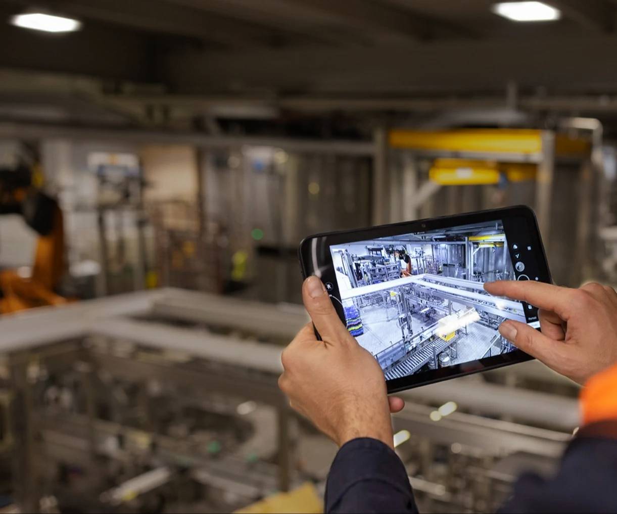industrial worker holding tablet with factory data